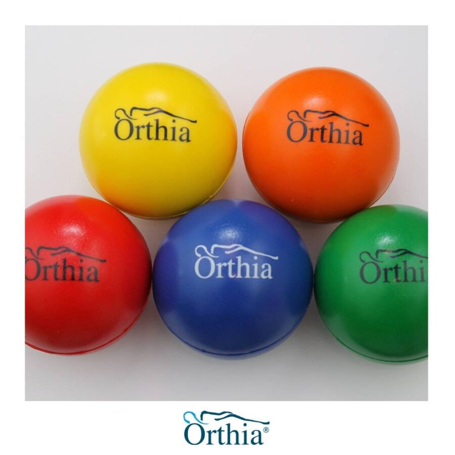 Cuatro bolas terapéuticas de colores con la palabra ortha impresa.