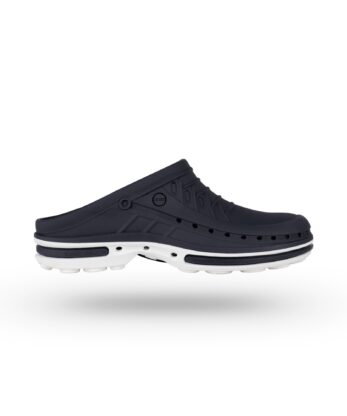 El Zueco Hospital Socas WOCK presenta un diseño slip-on negro con orificios de ventilación y una suela blanca en contraste, representada sobre un fondo blanco liso.