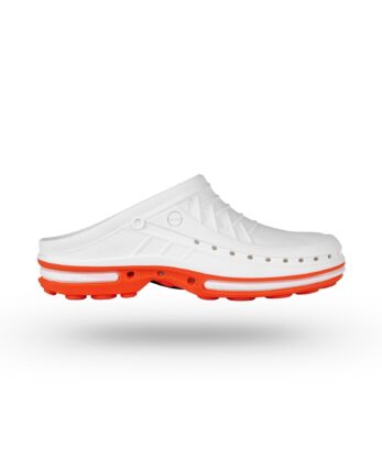 Sobre fondo blanco se muestra un zueco de hospital WOCK blanco con suela roja y perforaciones laterales.