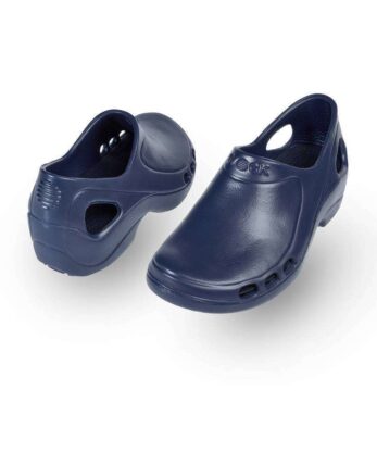 Un par de zuecos azules WOCK Flow obstruyen un fondo blanco.