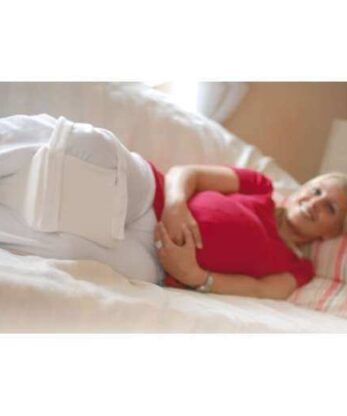 Una mujer embarazada descansa en la cama con un cojín Sissel colocado bajo la rodilla. El Sissel le proporcionará apoyo adicional para su comodidad durante.