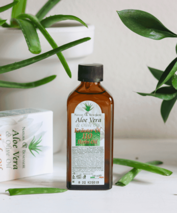 Una botella de N&B 110 Herb Oil 100ml junto a una planta.