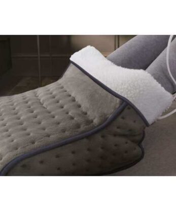 Una persona sentada en la cama utilizando el Calientapiés Eléctrico.