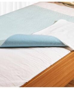 Un lit recouvert d'un drap de lit lavable Abri-Soft Blue 85X90cm.