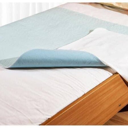 Un lit recouvert d'un drap de lit lavable Abri-Soft Blue 85X90cm.