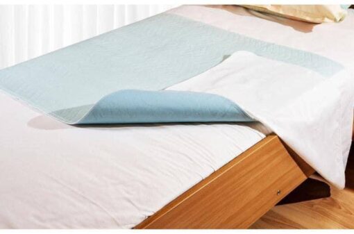 Un lit recouvert d'un drap de lit lavable Abri-Soft Blue 85X90cm.