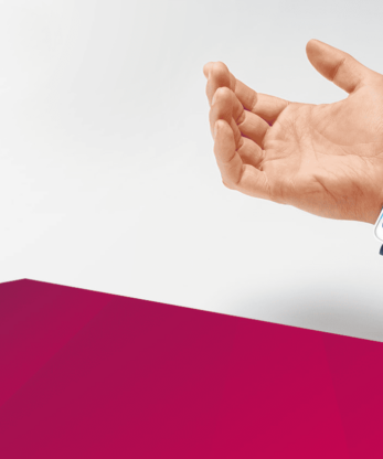 La mano de una persona sostiene un tensiómetro de pulso Veroval.