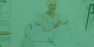 A woman sitting on a bed reading a book.