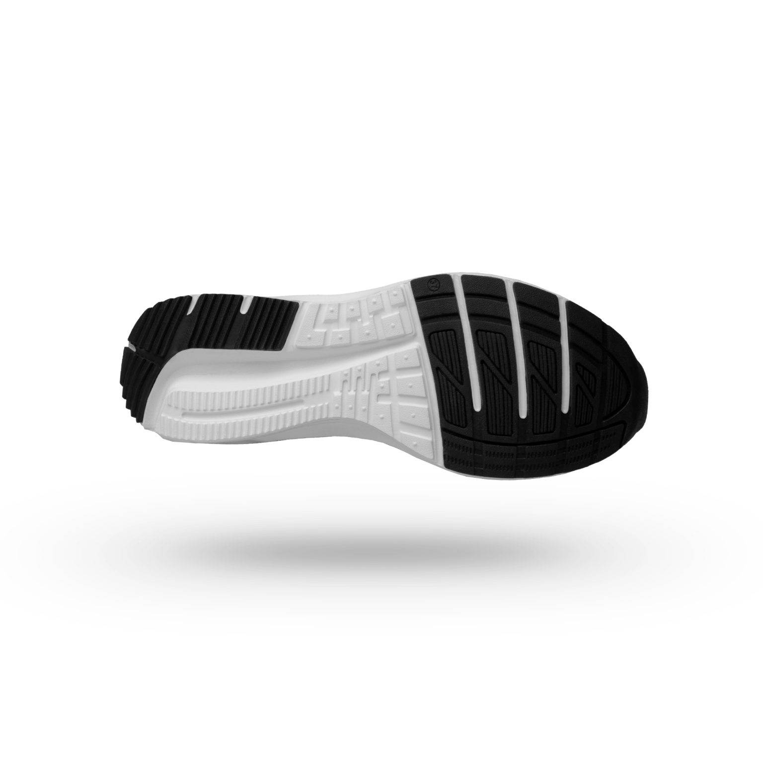 Bottom view of the sole of a black and white sports shoe showing various grooves and ridges for traction and comfort.