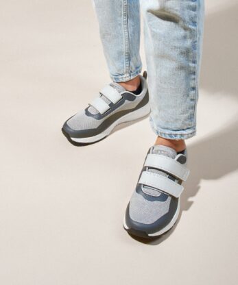 Une personne portant une paire de baskets REBLAST VELCRO et un jean.