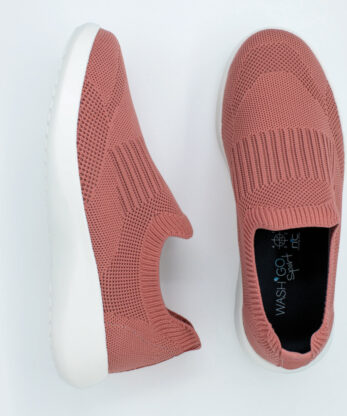 Une paire de baskets roses à semelles blanches sur fond blanc, avec la technologie Wash'Go.