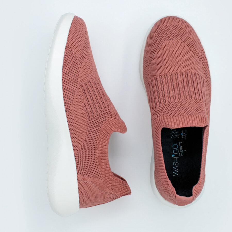 A pair of pink sneakers with white soles on a white background, with Wash'Go technology.