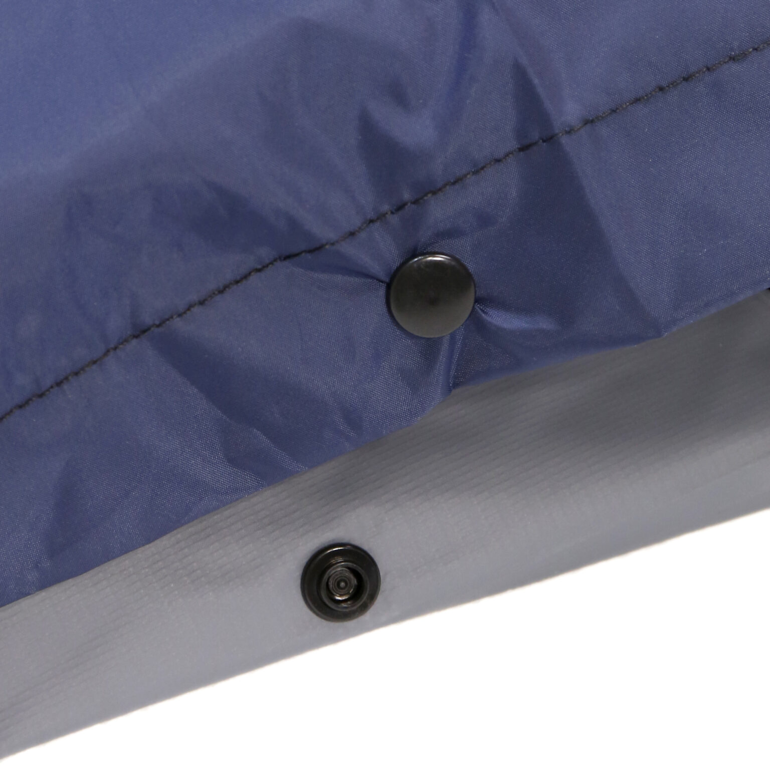 Close-up image of a Tubular Anti-decubitus Mattress with navy blue and gray Compressor fabric with black push buttons attached.