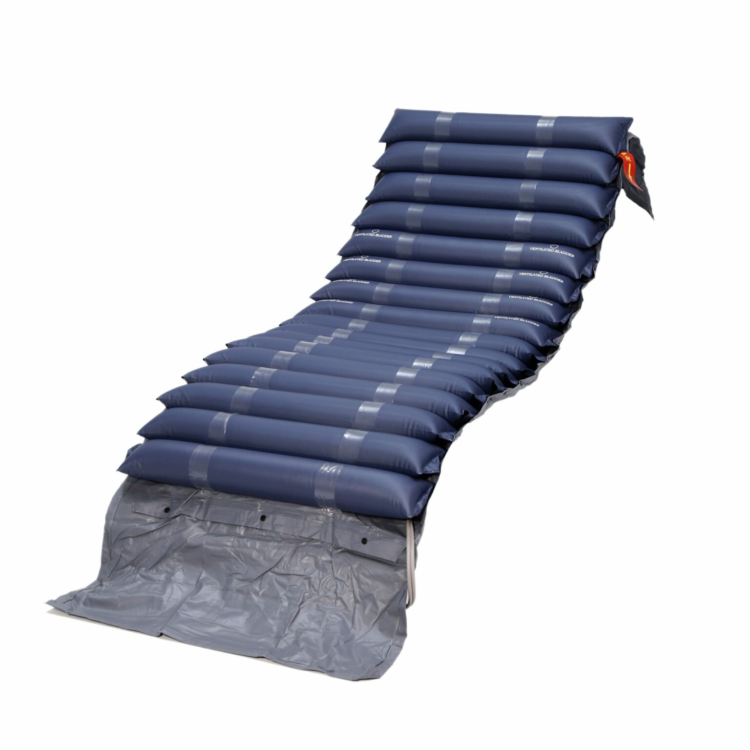 Tubular anti-decubitus mattress with compressor with segmented inflated blue chambers and gray base, positioned at a slight incline.