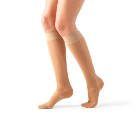 A person wearing knee-high compression socks Lycra Rest Socks AD 140 DEN in nude, standing with their feet slightly apart, against a plain white background.