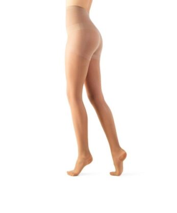 Uma pessoa usando meia-calça Meias Descanso Lycra AT 140 DEN transparente, cor nude, fica em pé sobre uma perna com a outra perna ligeiramente dobrada. A imagem captura a parte inferior do corpo, da cintura aos pés.