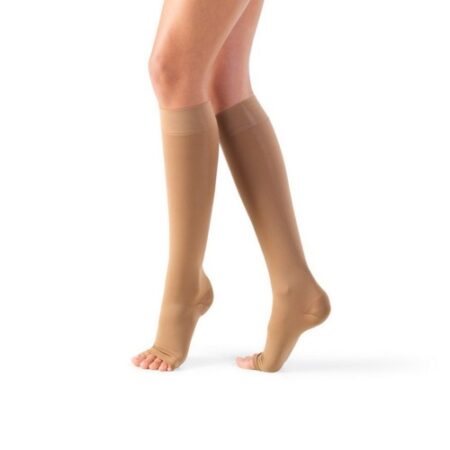 The person is wearing beige Lycra AD Class II Therapeutic Socks, knee-high compression socks with open toes, made of Lycra, on a plain white background. These stockings are designed for optimal support and comfort.